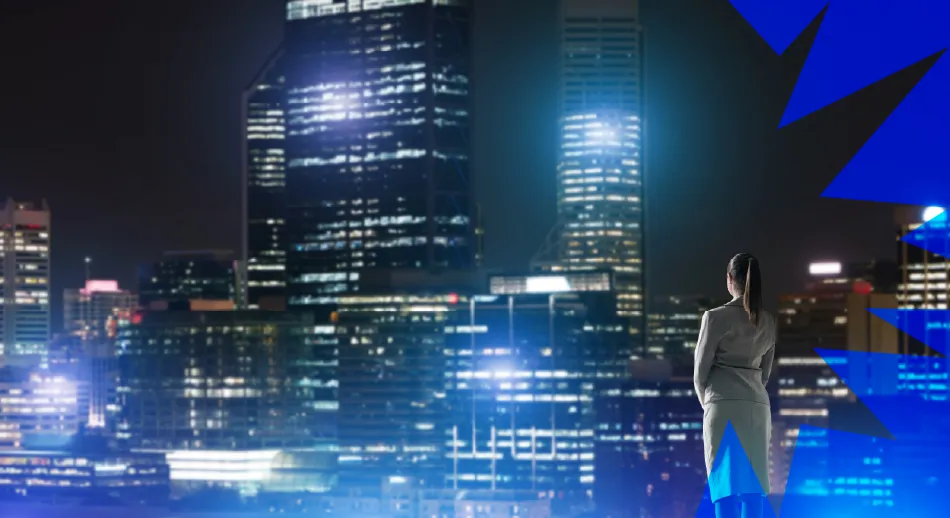 Donna osserva una città futuristica illuminata, rappresentazione visiva dei megatrend globali che influenzano lo sviluppo urbano e tecnologico