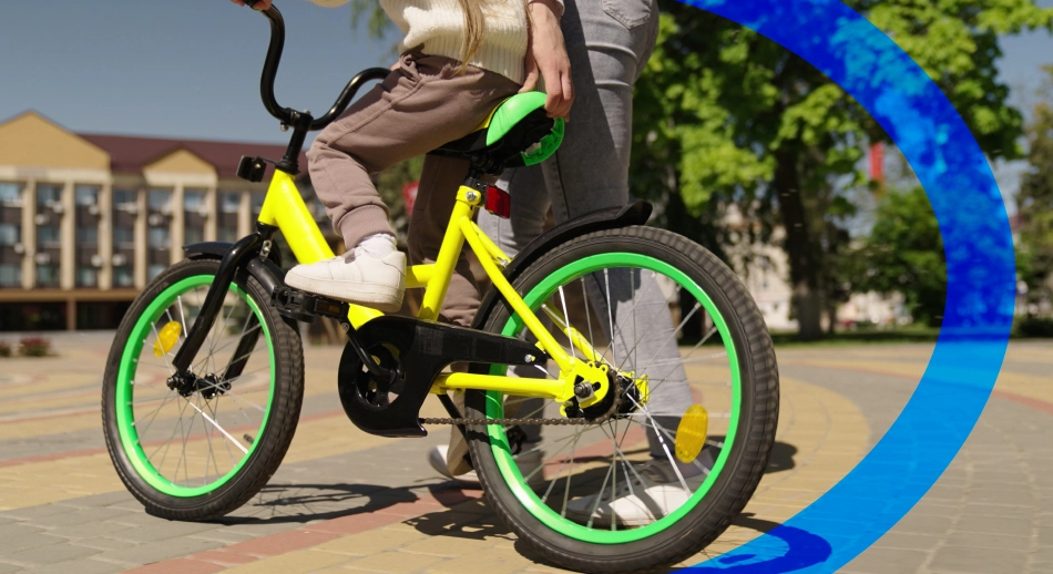 Bambina che sta imparando ad andare sulla bicicletta a simulare le sfide di valutazione un progetto europeo